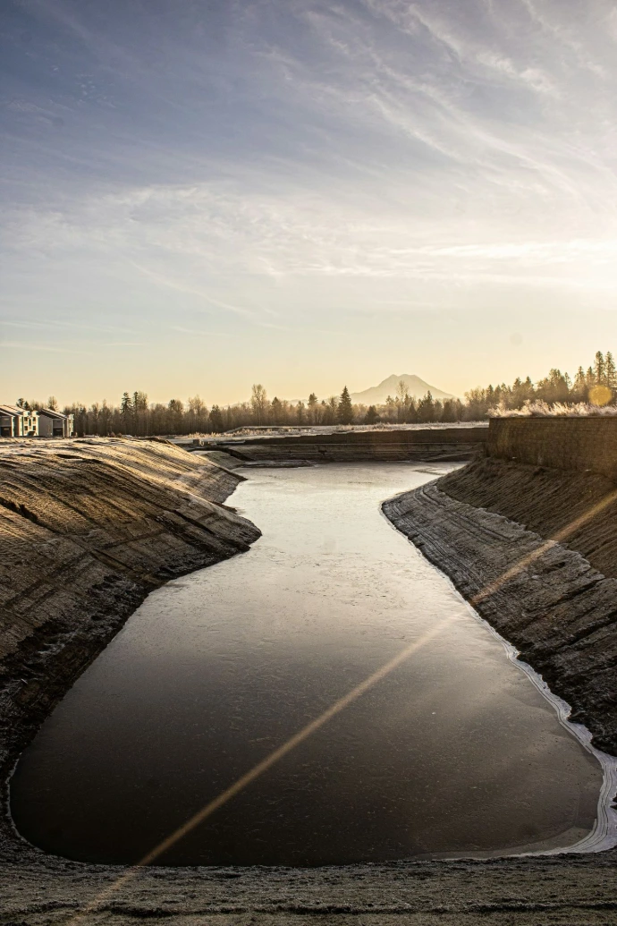 A large body of water surrounded by dirt